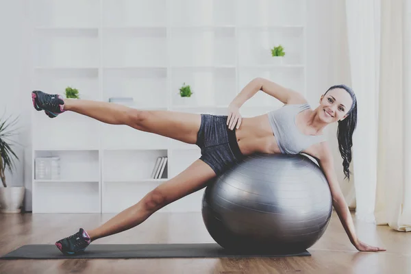 Pretty woman med övning boll hemma. Fitness — Stockfoto