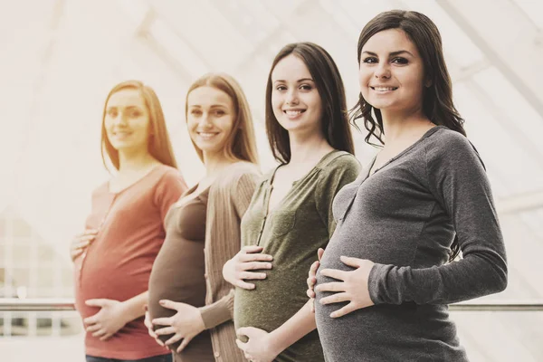 Side view of four smiling pregnant women — Stock Photo, Image