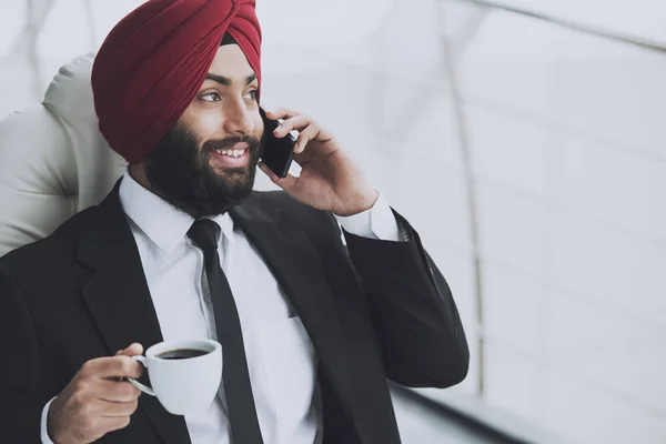 Smiling indian businessman drinking coffee — Stock Photo, Image
