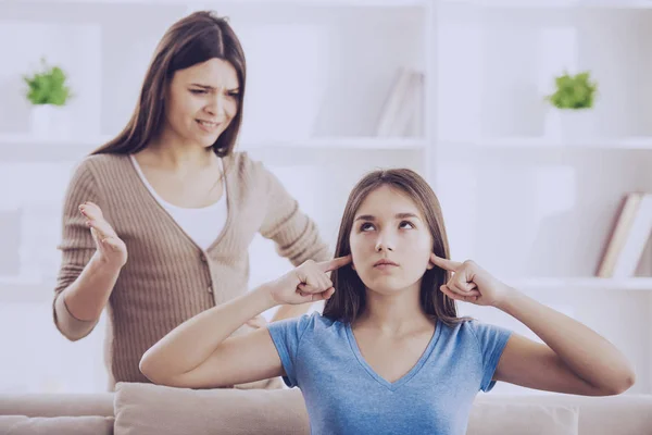 Teen closed ears with hands while mom yells — Stock Photo, Image