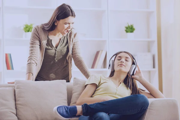 Adolescent oreilles fermées avec casque tandis que maman crie — Photo