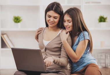 Katta otururken dizüstü kullanarak anne