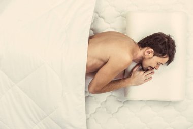 Üstten görünüm. Yatakta uyuyan adam genç beyaz sakallı