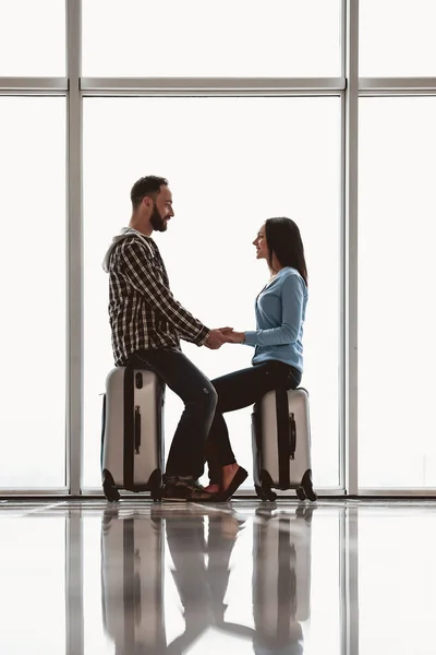 Paar houdt handen in de buurt van koffer in luchthaven — Stockfoto