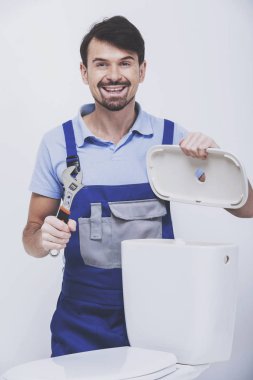 Tesisatçı tuvalet onarıyor.