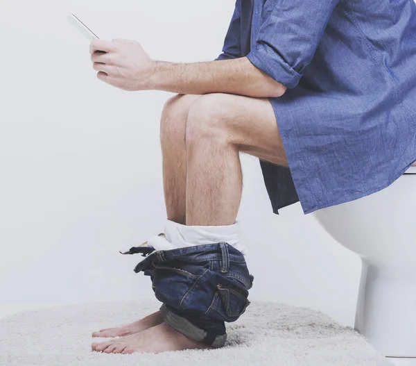 Junger Mann benutzt Laptop auf Toilette. — Stockfoto