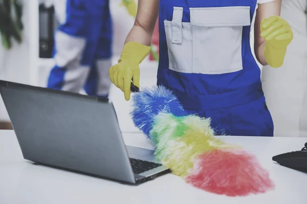 Vrouw schoonmaak computer met penseel in office. — Stockfoto