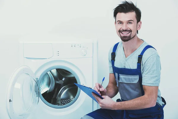 Retrato del joven reparador sonriente de pie con su portapapeles . —  Fotos de Stock