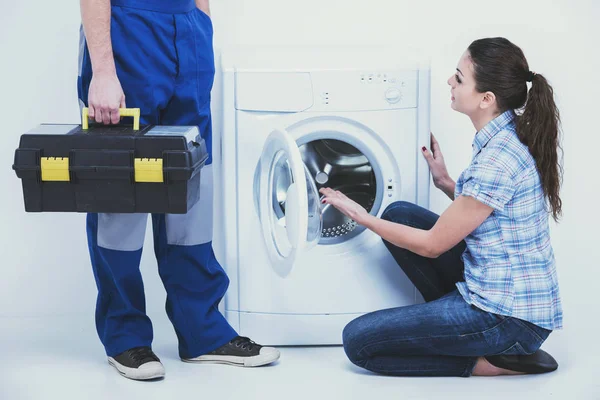 Молода домогосподарка і ремонтник біля пральної машинки . — стокове фото