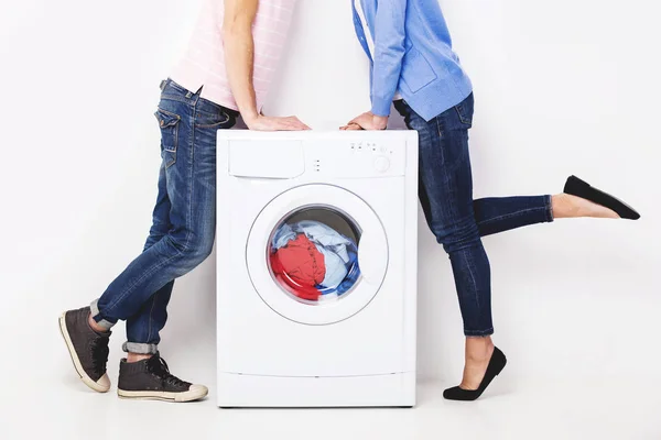 Casal beijando perto da máquina de lavar roupa . — Fotografia de Stock