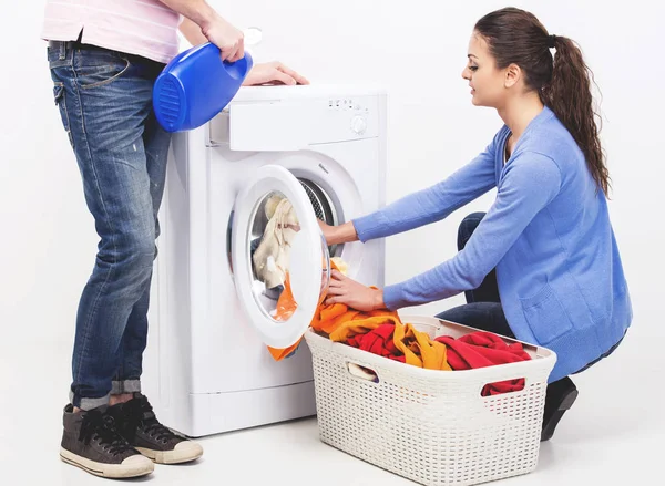 Молода пара займається пранням вдома . — стокове фото