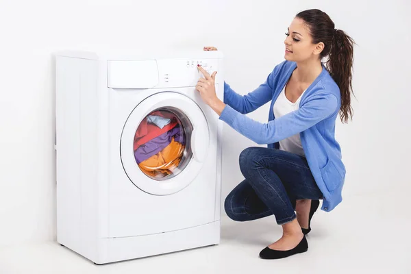 Genç kadın acil düğmesi çamaşır makinesi, closeup — Stok fotoğraf