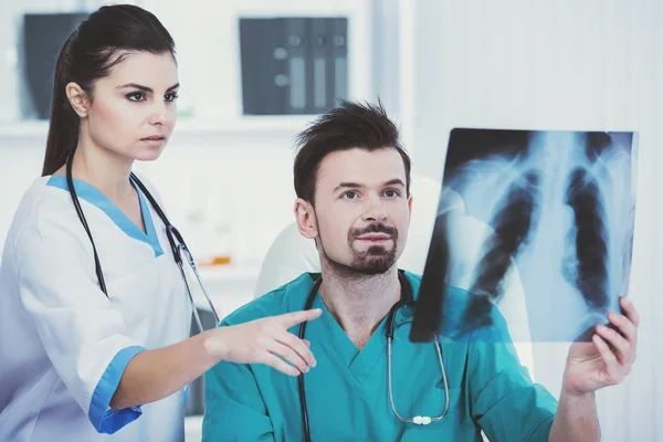 Lekarz w zielonej sukni medycznych posiada rentgen. — Zdjęcie stockowe