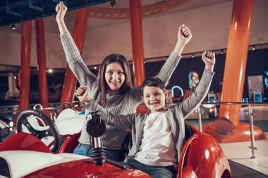 Mutlu anne ve oğlu oyuncak araba üzerinde oturan gülümsüyor. Aile ile birlikte tatil geçirmek. Eğlence Merkezi, Alışveriş Merkezi, eğlence parkı. Aile dinlenme, eğlence kavramı.