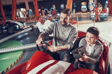 Smiling father and son in amusement center. Spending holiday together with family. Entertainment center, mall, amusement park. Family rest, leisure concept. clipart