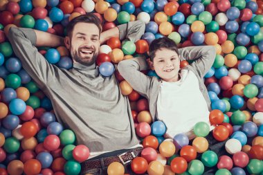 Üstten görünüm. Mutlu baba ve oğul havuz topları ile. Aile dinlenme, eğlence kavramı. Birlikte tatil geçirmek. Eğlence Merkezi, Alışveriş Merkezi, eğlence parkı.