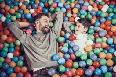 Üstten görünüm. Joyfull baba ve oğul her diğer insanları izleyerek topları ile havuzunda. Dinlenme, tatil, eğlence. Birlikte vakit. Eğlence Merkezi, Alışveriş Merkezi, eğlence parkı.