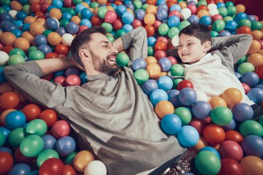 Üstten görünüm. Joyfull baba ve oğul her diğer insanları izleyerek topları ile havuzunda. Dinlenme, tatil, eğlence. Birlikte vakit. Eğlence Merkezi, Alışveriş Merkezi, eğlence parkı.