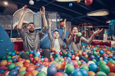 Mutlu bir aile havuzu topları ile oturuyor. Aile dinlenme, eğlence. Birlikte tatil geçirmek. Eğlence Merkezi, Alışveriş Merkezi, eğlence parkı.