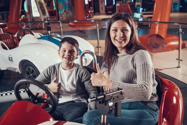 Anne ve oğlu oyuncak araba içinde gülümseyen mutlu. Aile ile birlikte tatil geçirmek. Eğlence Merkezi, Alışveriş Merkezi, eğlence parkı. Aile dinlenme, eğlence kavramı.