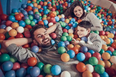 Üstten görünüm. Mutlu bir aile havuzu topları ile yalan. Aile dinlenme, eğlence kavramı. Birlikte tatil geçirmek. Eğlence Merkezi, Alışveriş Merkezi, eğlence parkı.