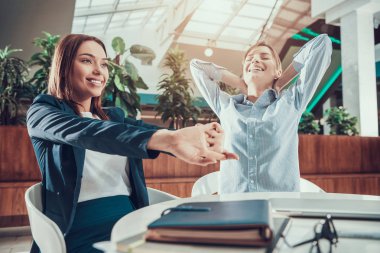 İki kadın ofiste germe egzersiz.