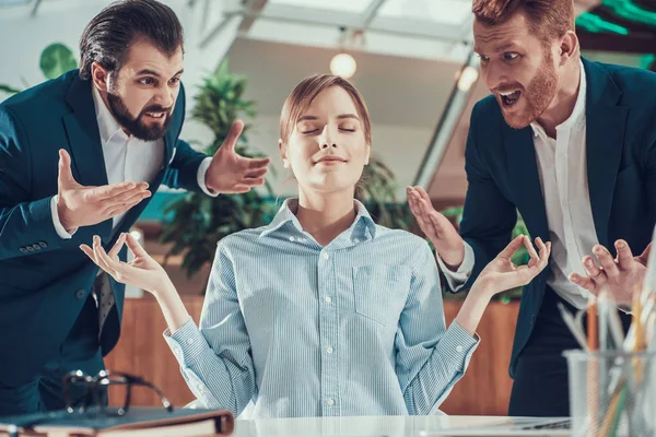 La gente le grita a un trabajador meditante en la oficina . — Foto de Stock