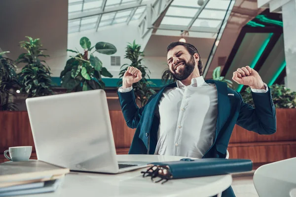 Hombre trabajador ejercitando brazos extendidos en la oficina . —  Fotos de Stock