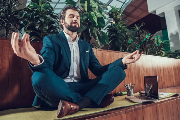 Чоловік працівник медитує на лавці в офісі . — стокове фото