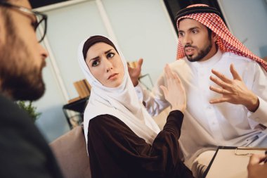 Arap çift savunarak bir terapist ile resepsiyonda. Psikolojik yardım aile için. Aile psikolog ofisinde endişe sorunları tartışma.