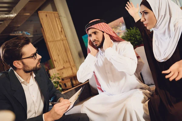 Arap adam terapistin resepsiyonda kulakları pokes. Aile sorunları Office psikolog tartışılması.