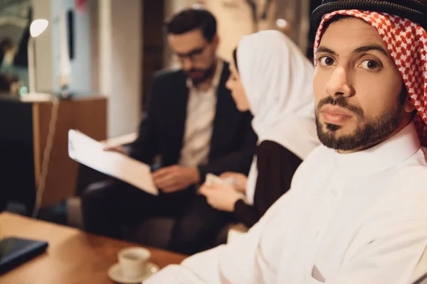 Discouraged Arab man with wife at psychologist reception. Family psychotherapy concept.