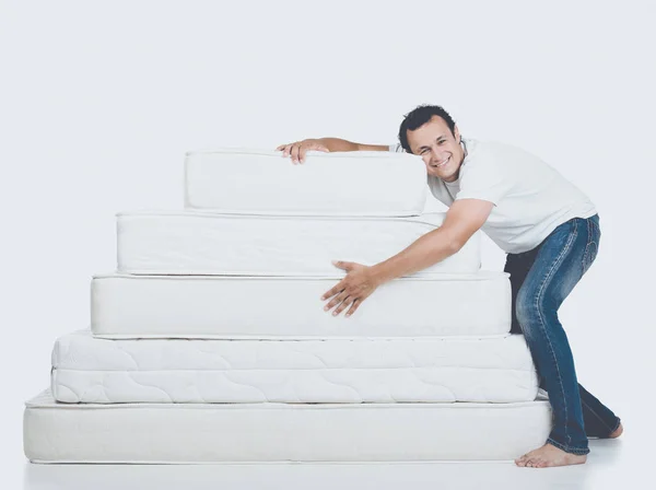 Hombre sonriente acostado en la pirámide del colchón —  Fotos de Stock