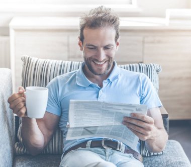 Beyaz işadamı dinlenme kanepe okuma gazete.