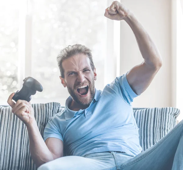 Homem excitado fascinado pelo jogo no console em casa . — Fotografia de Stock