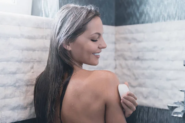 Jovem sorrindo mulher tomando banho seus olhos fechados . — Fotografia de Stock