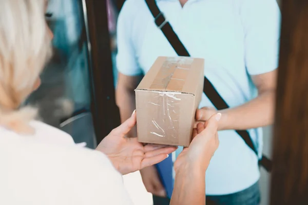 Cercano.Courier Entregado pequeño paquete a la mujer . — Foto de Stock