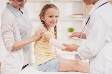 Doktor geri sarar el bir bandaj ile küçük kız.