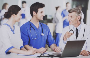 Group of Doctors with Laptop Discusses Operation. clipart