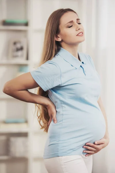 Νεαρά έγκυος κορίτσι που υποφέρουν από πόνο στο σπίτι. — Φωτογραφία Αρχείου
