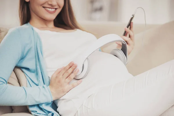 Närbild. Glad gravid flicka Luing på soffan. — Stockfoto