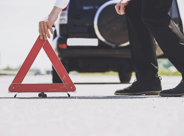 De cerca. Los hombres ponen triángulo rojo de advertencia con el coche . — Foto de Stock