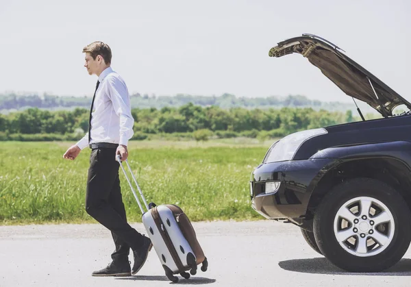 Joven hombre de negocios con maleta se aleja por carretera — Foto de Stock
