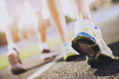 Yakın çekim. Genç sportif koşucular Sprint çalıştırmak için hazır