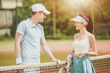 Genç çift tenis oyuncuları sahaya iletişim kurar.