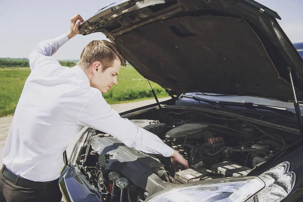 Jonge zakenman onderzoeken gebroken auto bezorgd — Stockfoto