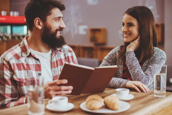 Attraktives junges Paar liest Buch. — Stockfoto