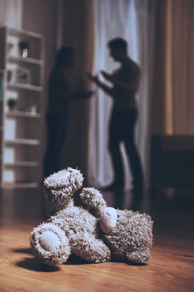 Teddy Bear on Floor and Conflicted Parents. — Stock Photo, Image