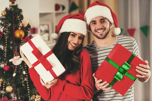 Casal alegre segurando presentes de Natal . — Fotografia de Stock