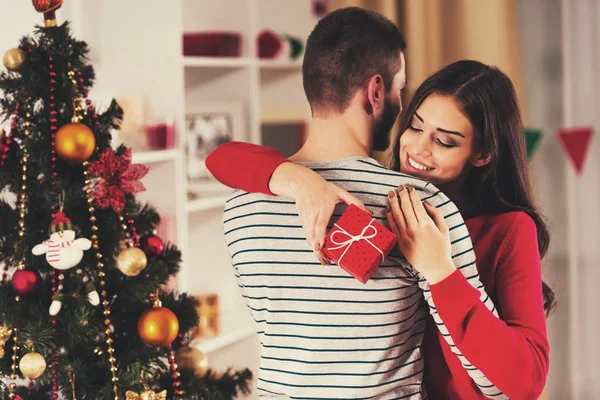 Ragazza con regalo rosso abbracciare fidanzato . — Foto Stock